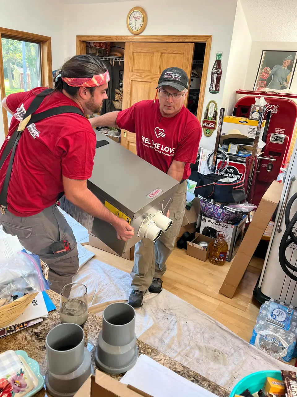 Lennox technicians installing a heating or cooling system for a family in need